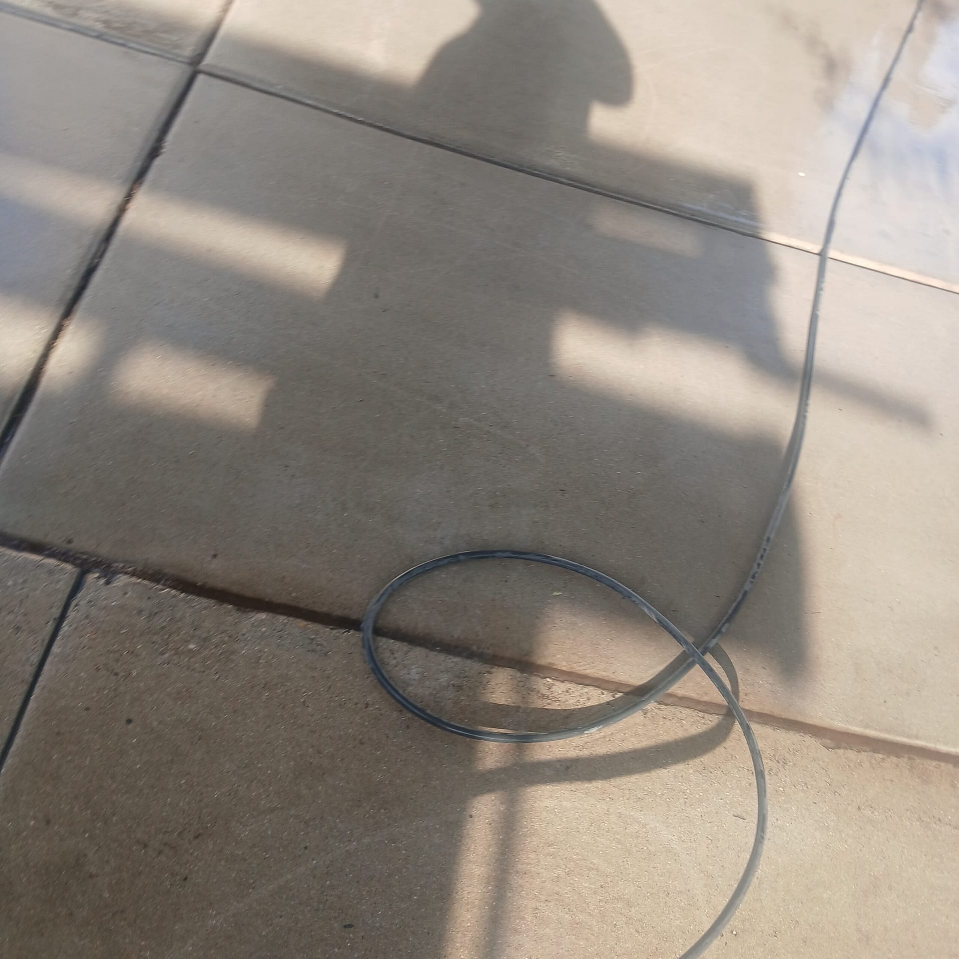 Breasy pressure washing a two-car driveway at a Scottsdale rental property