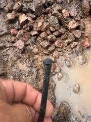 Wet gravel revealing a hidden drip line leak on a Scottsdale desert-scape lot