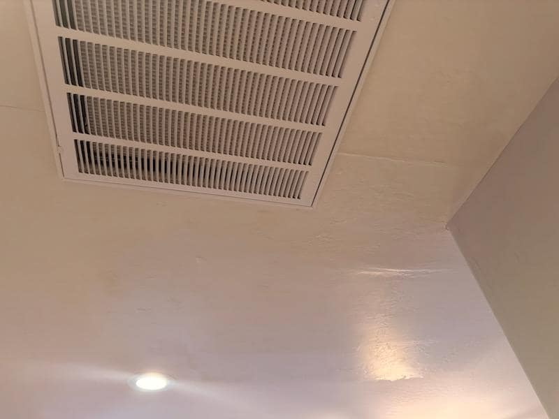 Painted wall and ceiling corner with vent at a Cave Creek property